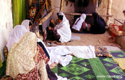 Afghan women in a RAWA carpet-weaving workplace.