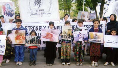 Children holding photos to describe the crimes committed by the fundamentalists in Afghanistan