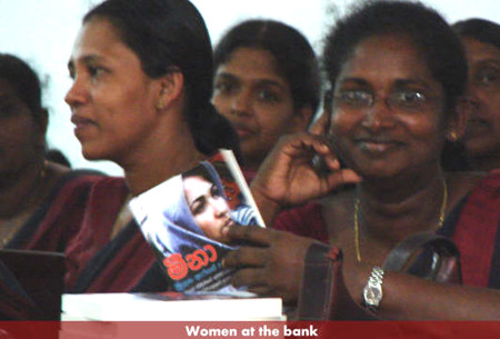 women at the bank holding a copy of the book