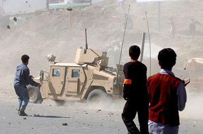 A US military Humvee speeds away under a hail of stones thrown by protestors in Kabul, Afghanistan