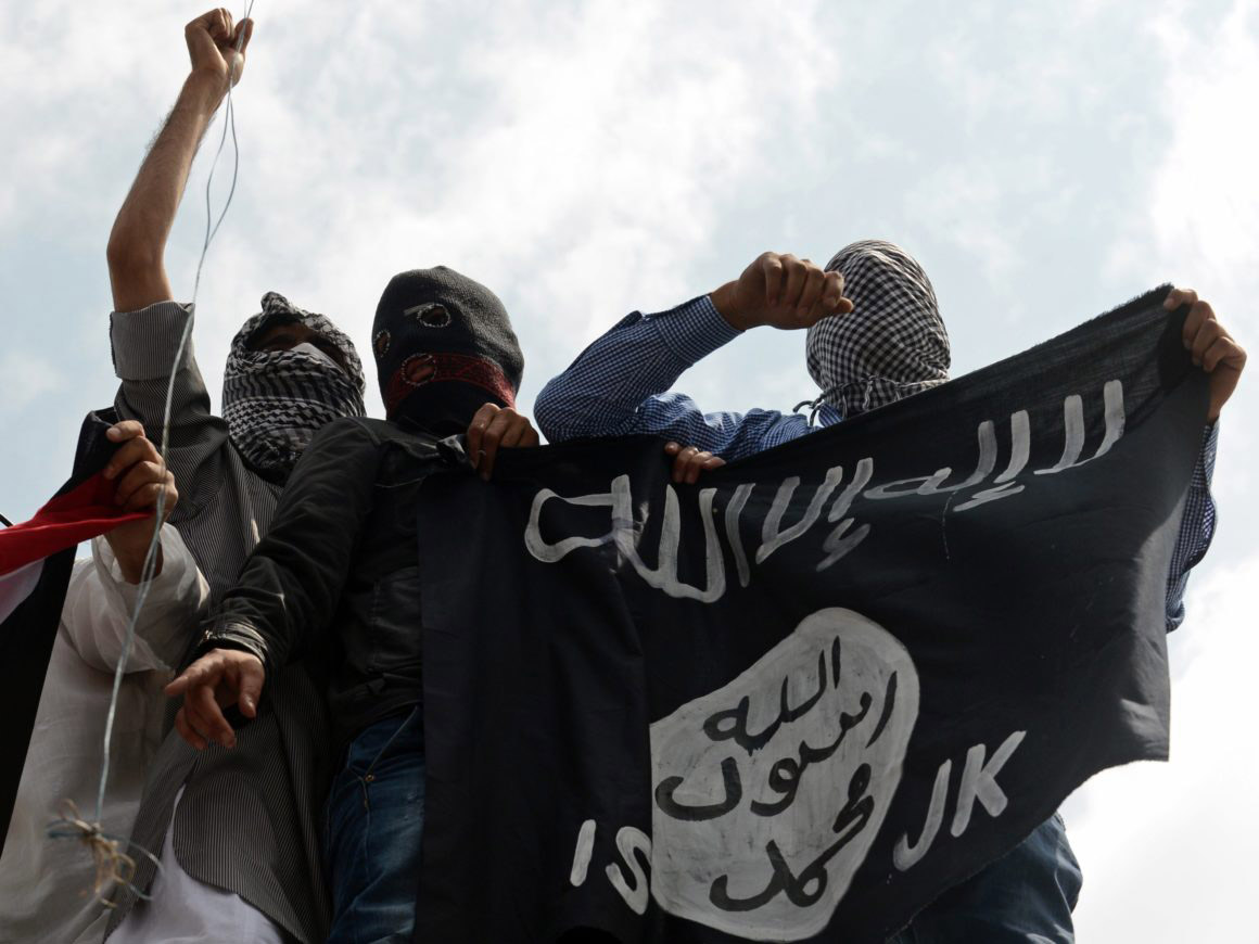 Islamic State supporters hold up the caliphate's flag. Photo: Taussef Mustafa/AFP