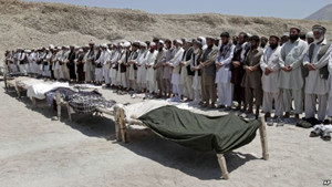 Afghan men offer funeral prayers near the bodies of 7 civilians killed