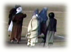 Le guardie armate talebane la spingono nel centro del campo di calcio per l'esecuzione capitale. 